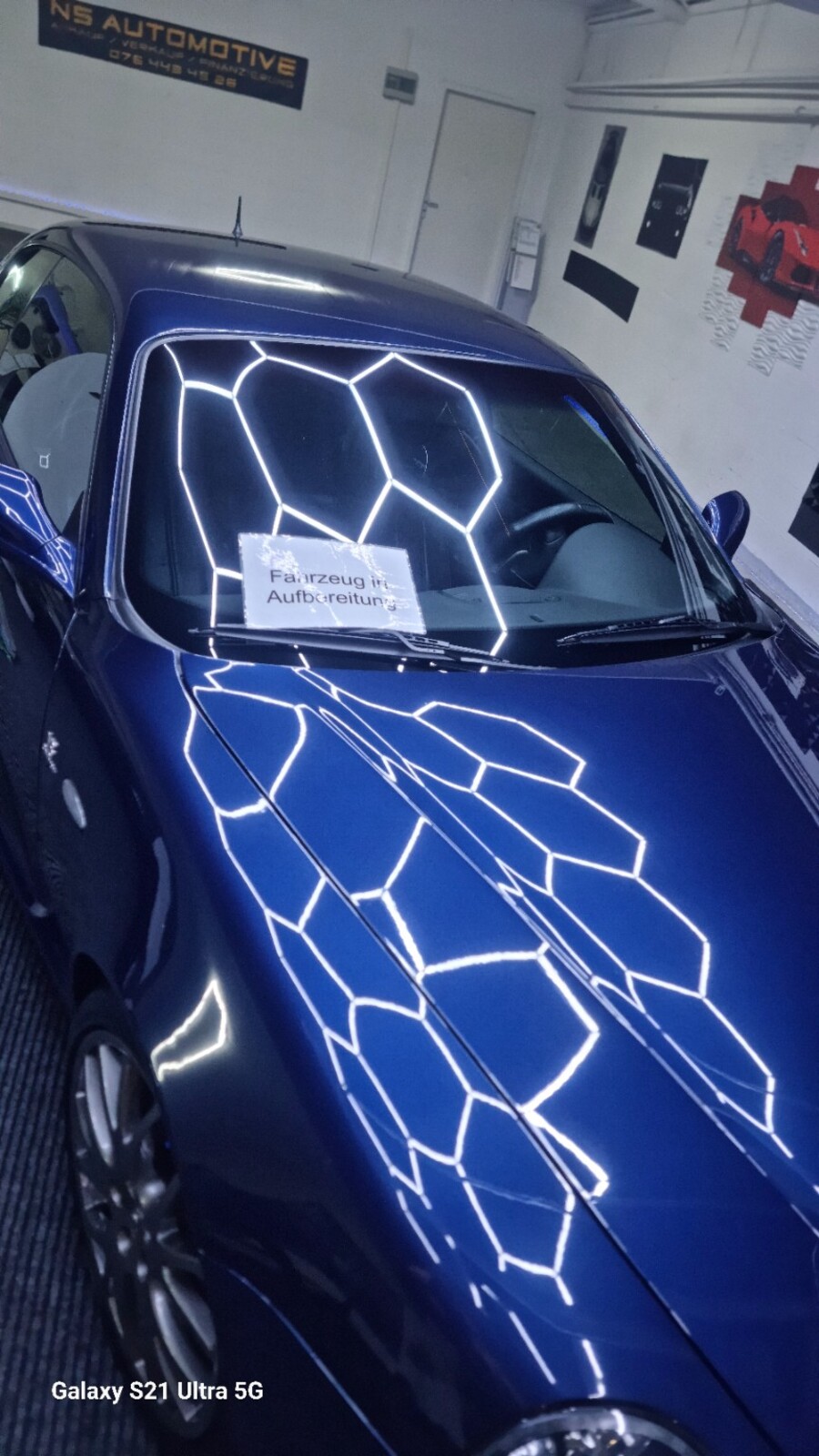 Glänzende blaue Motorhaube und Windschutzscheibe der Maserati mit Lichtreflexionen