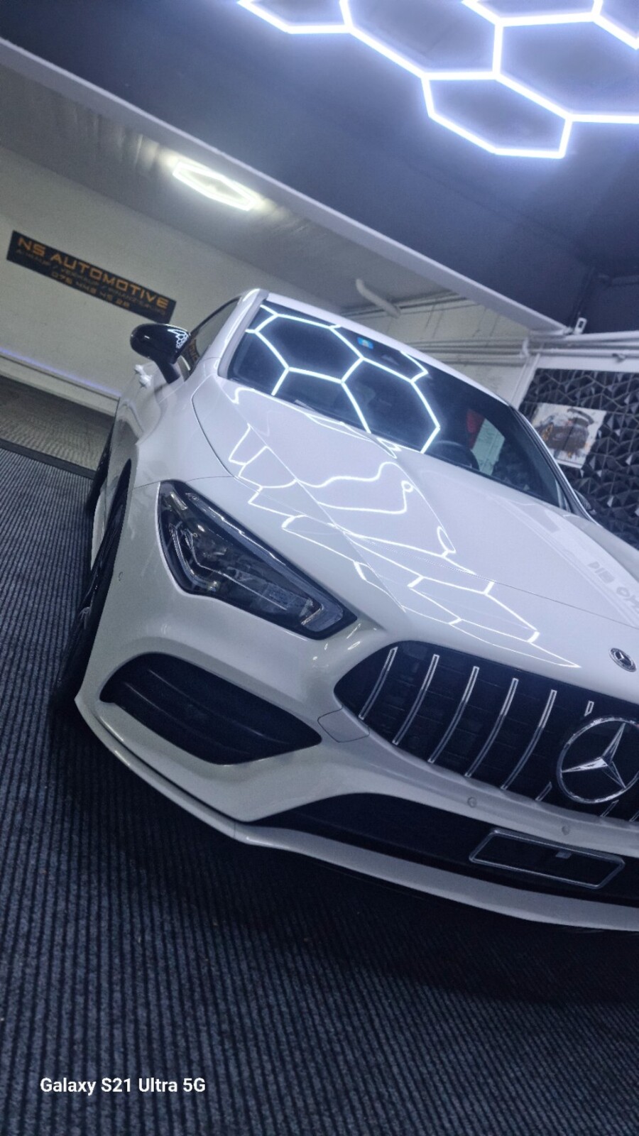 Weisser Mercedes in der Garage unter den Aufbereitungsleuchten
